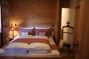 Schlafzimmer mit Doppelbett und angrenzendem Badezimmer